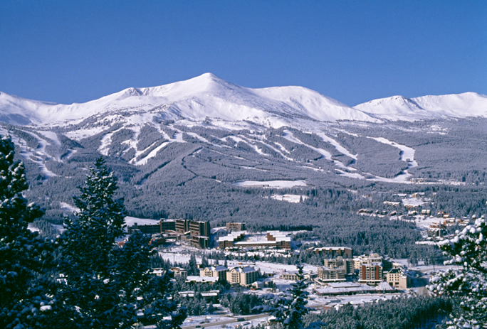 Picture of Breckenridge snow-capped mountain with Colorado rental homes beneath.
